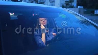 女孩坐在汽车的车轮前，嘴唇上涂着唇彩